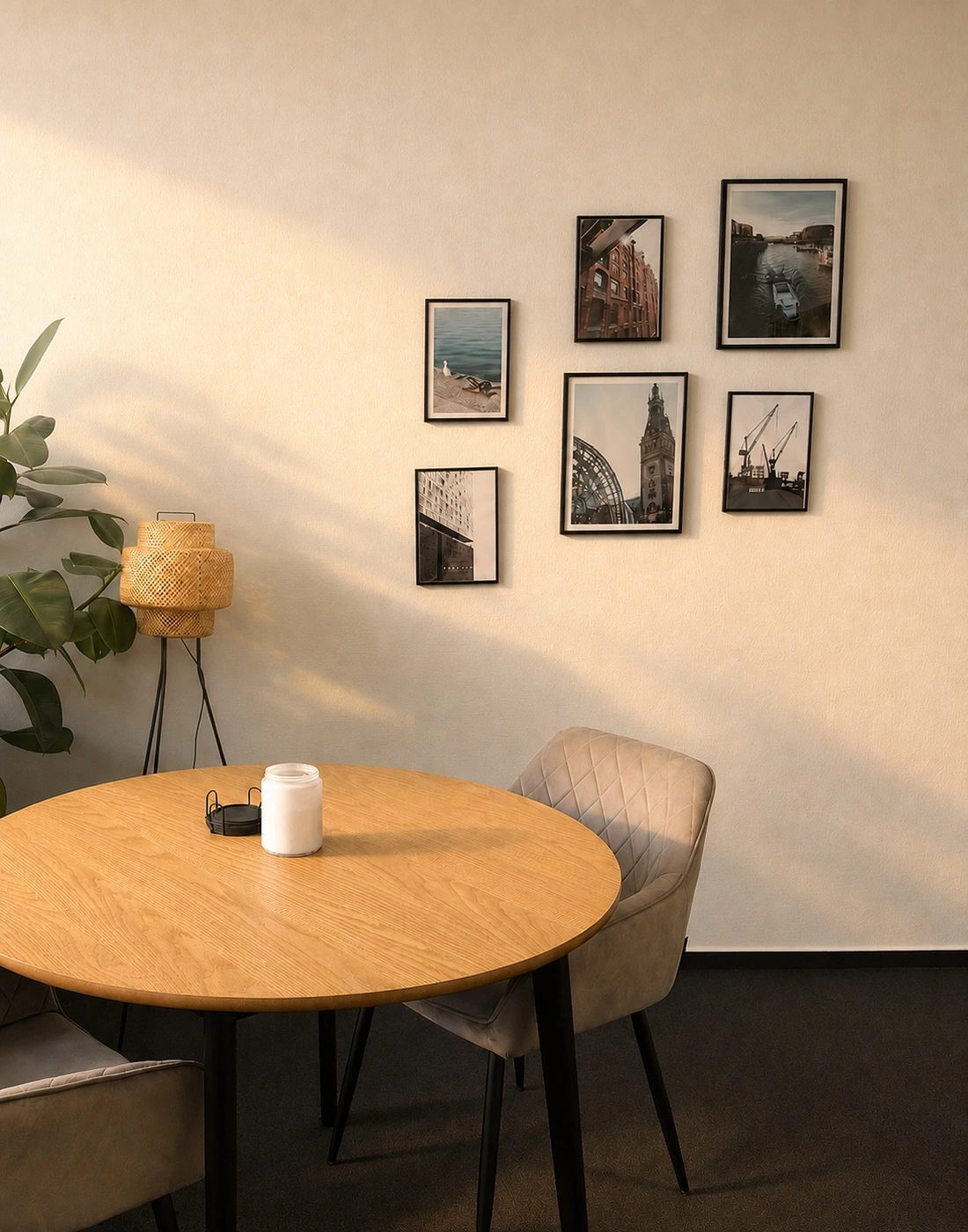 Beratungsecke von HANSE.TAX mit rundem Holztisch, Polsterstühlen und Bilderwand mit Hamburg-Motiven